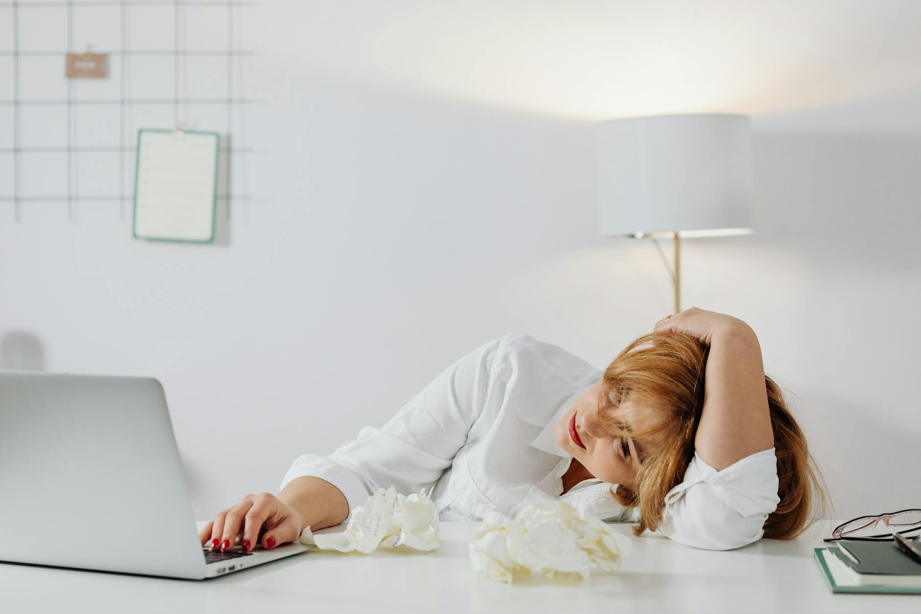 Femme epuisee la tete dans les mains a son bureau, signe d'epuisement professionnel