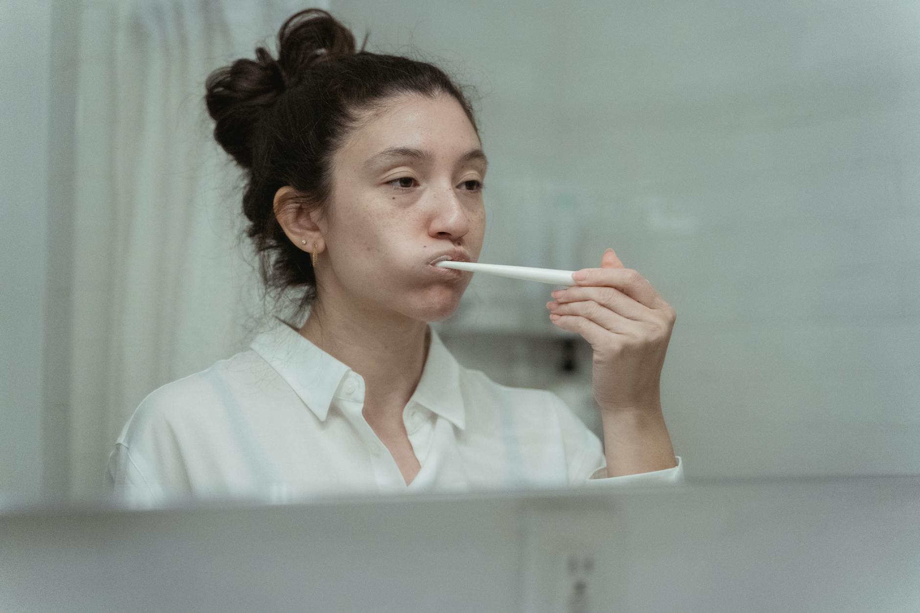 Brosse a dents et verre d'eau dans une salle de bain claire, hygiene du matin