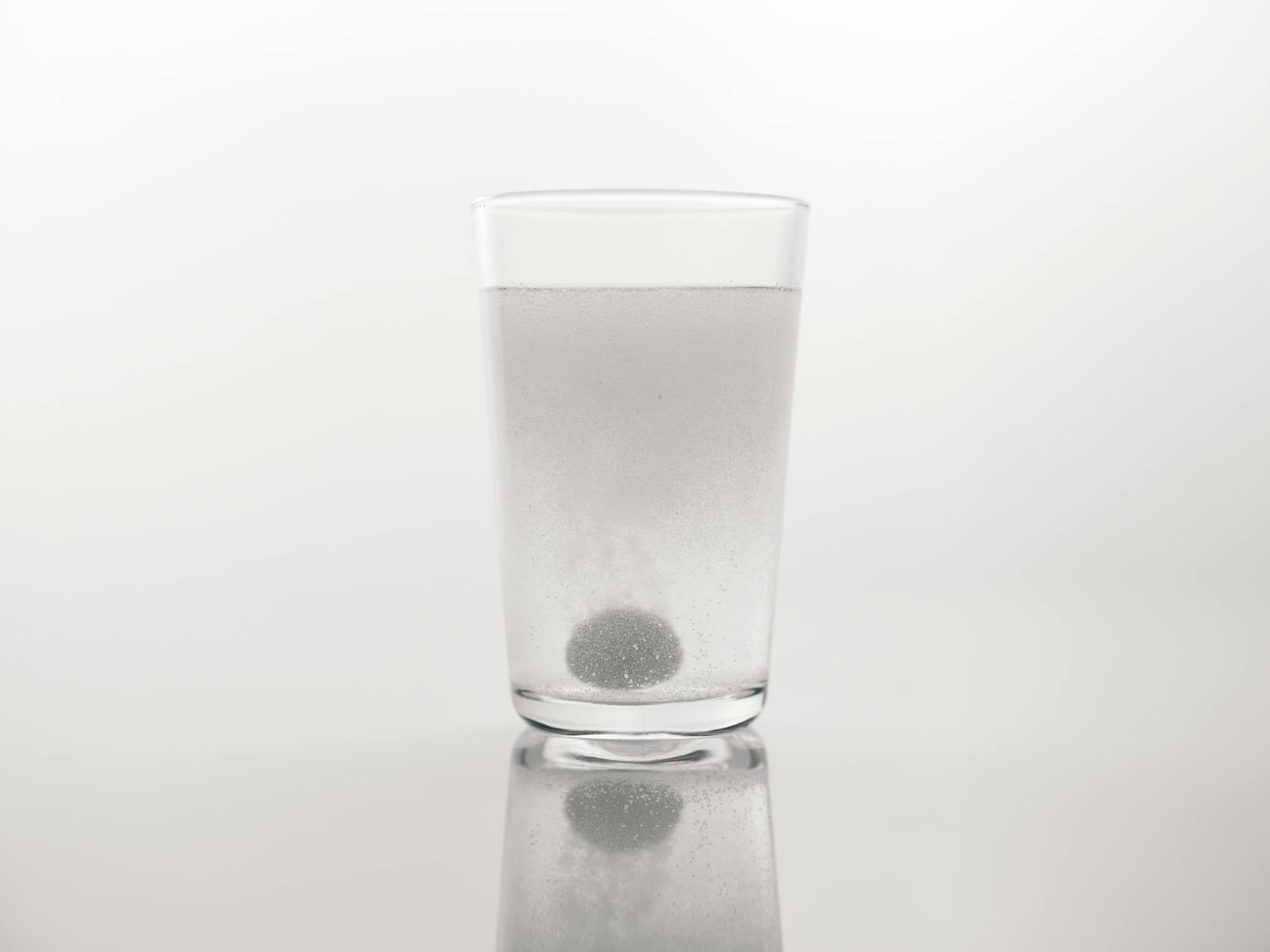 Verre d'eau posé sur une table en bois clair