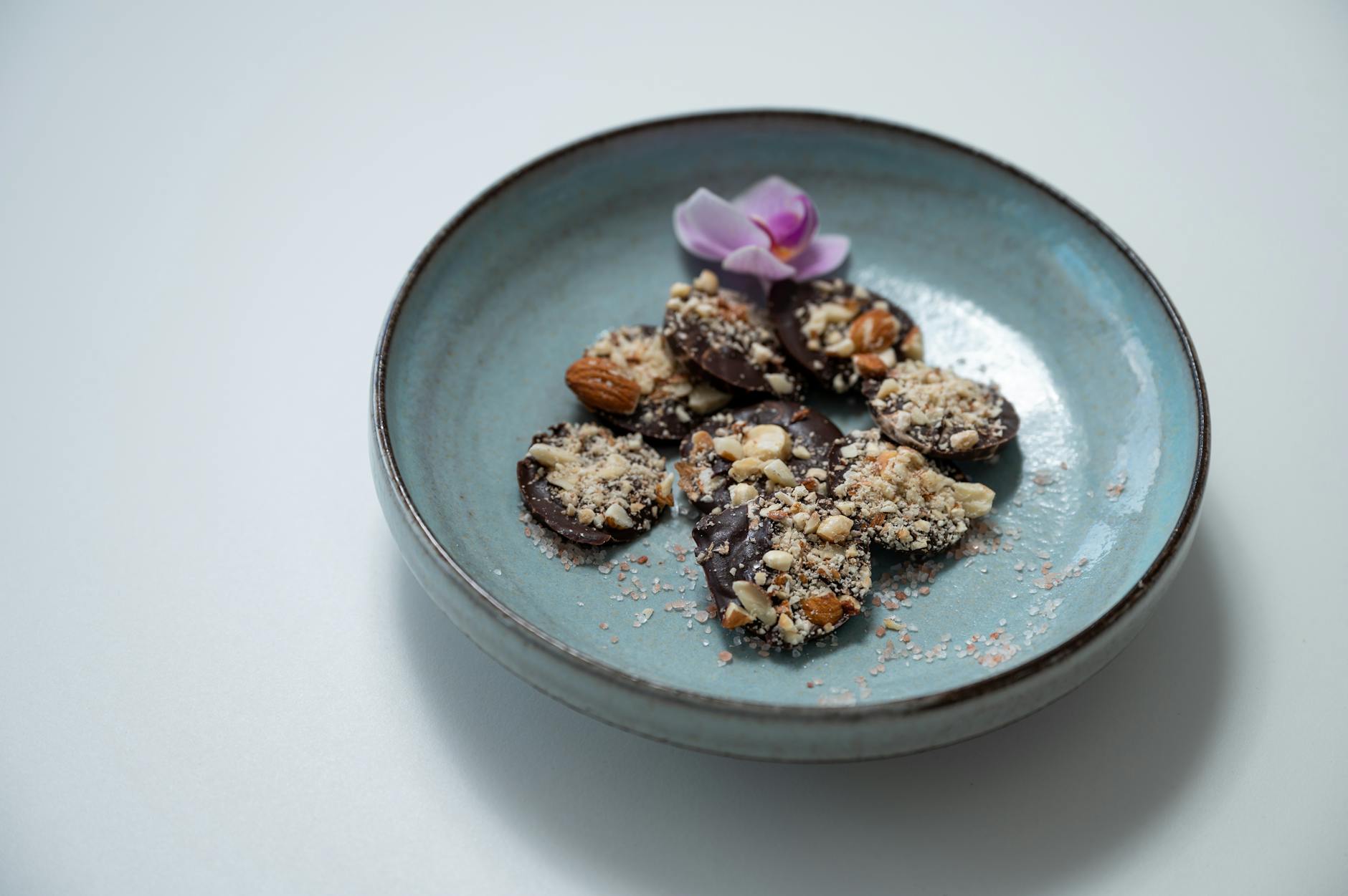 Amandes, chocolat noir et graines sur une planche en bois