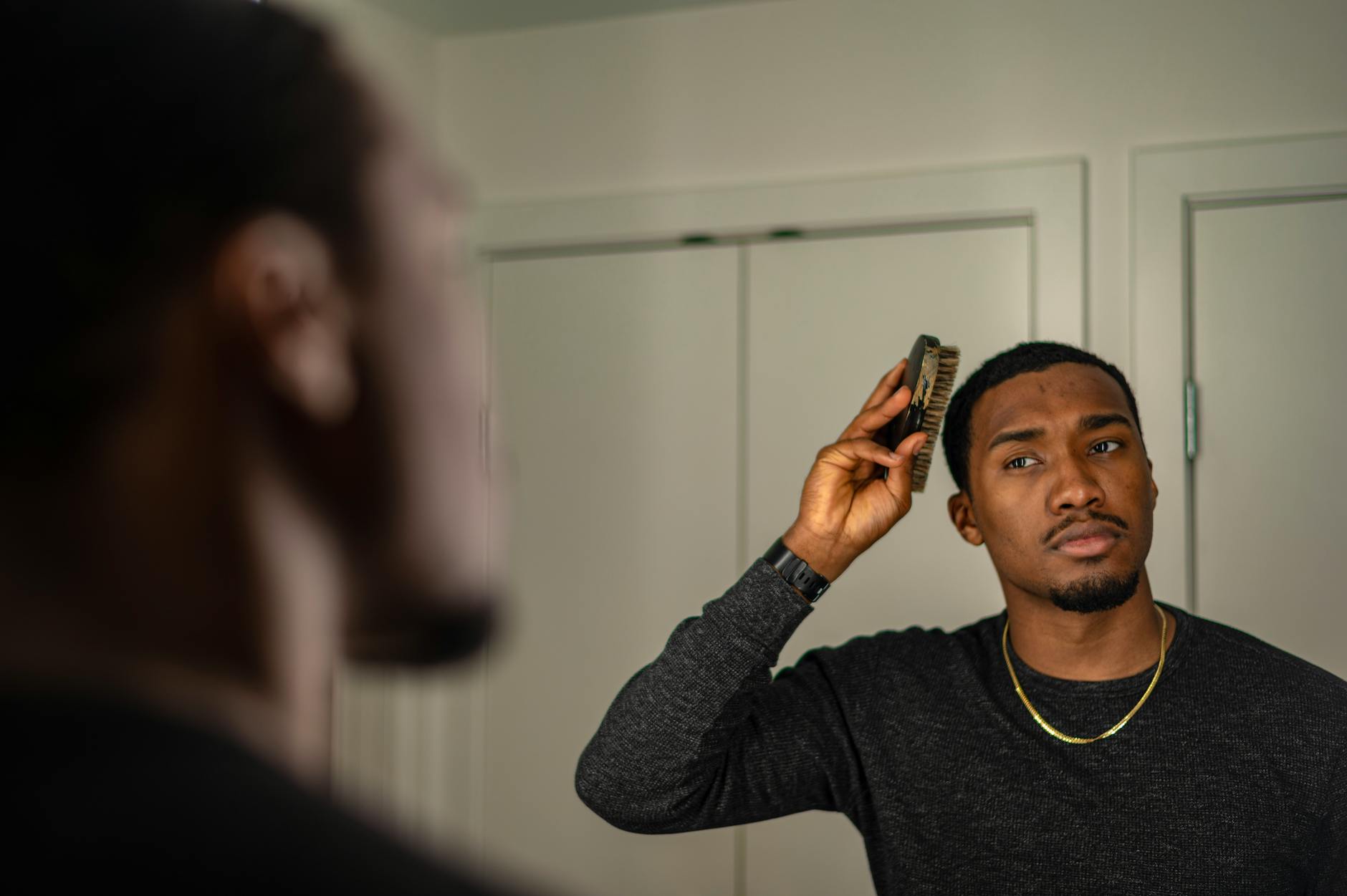 Homme confiant examinant ses cheveux dans un miroir