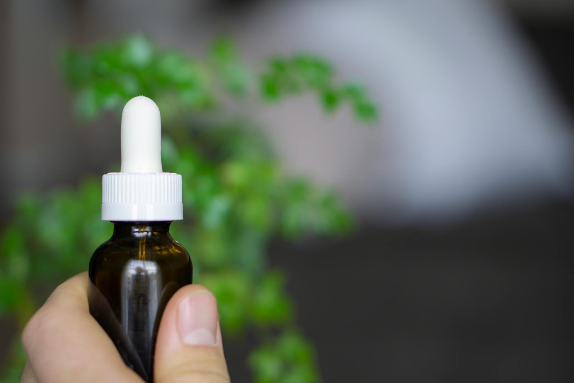 Flacon de complement naturel a base de plantes pose sur un plan epure
