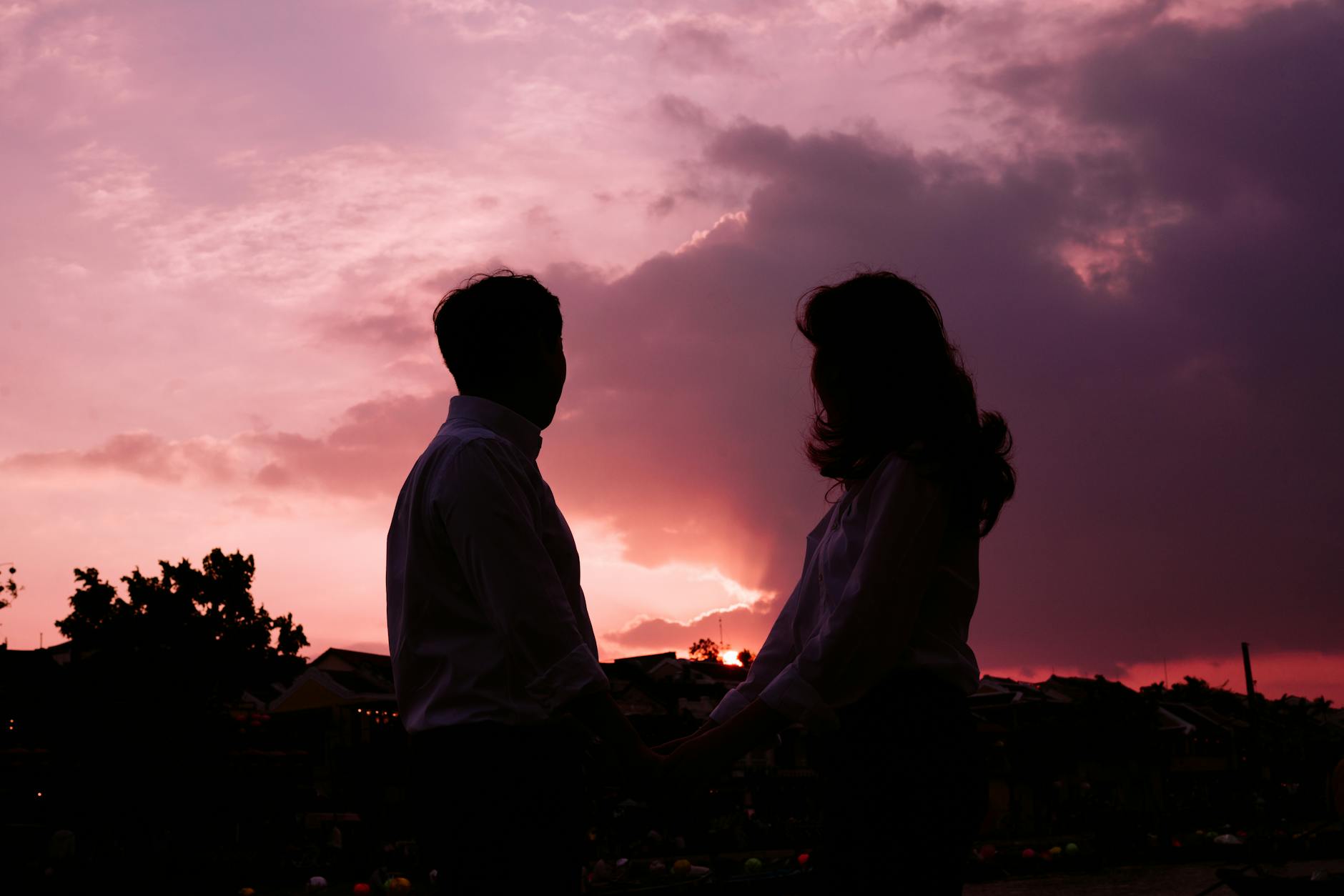 Couple se tenant la main au coucher du soleil