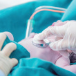 Pédiatre examinant délicatement le cou d'un bébé souriant