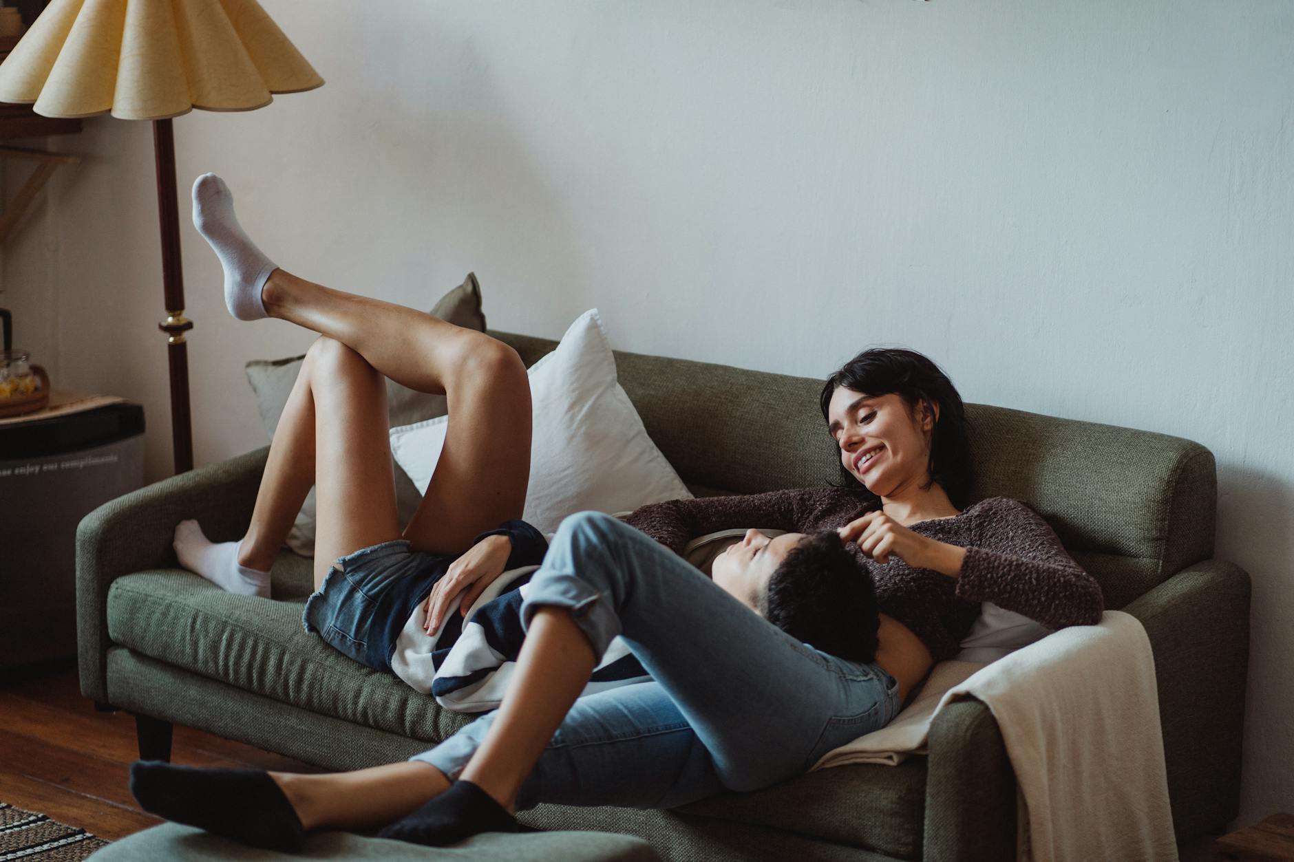 Couple souriant en complicité sur un canapé