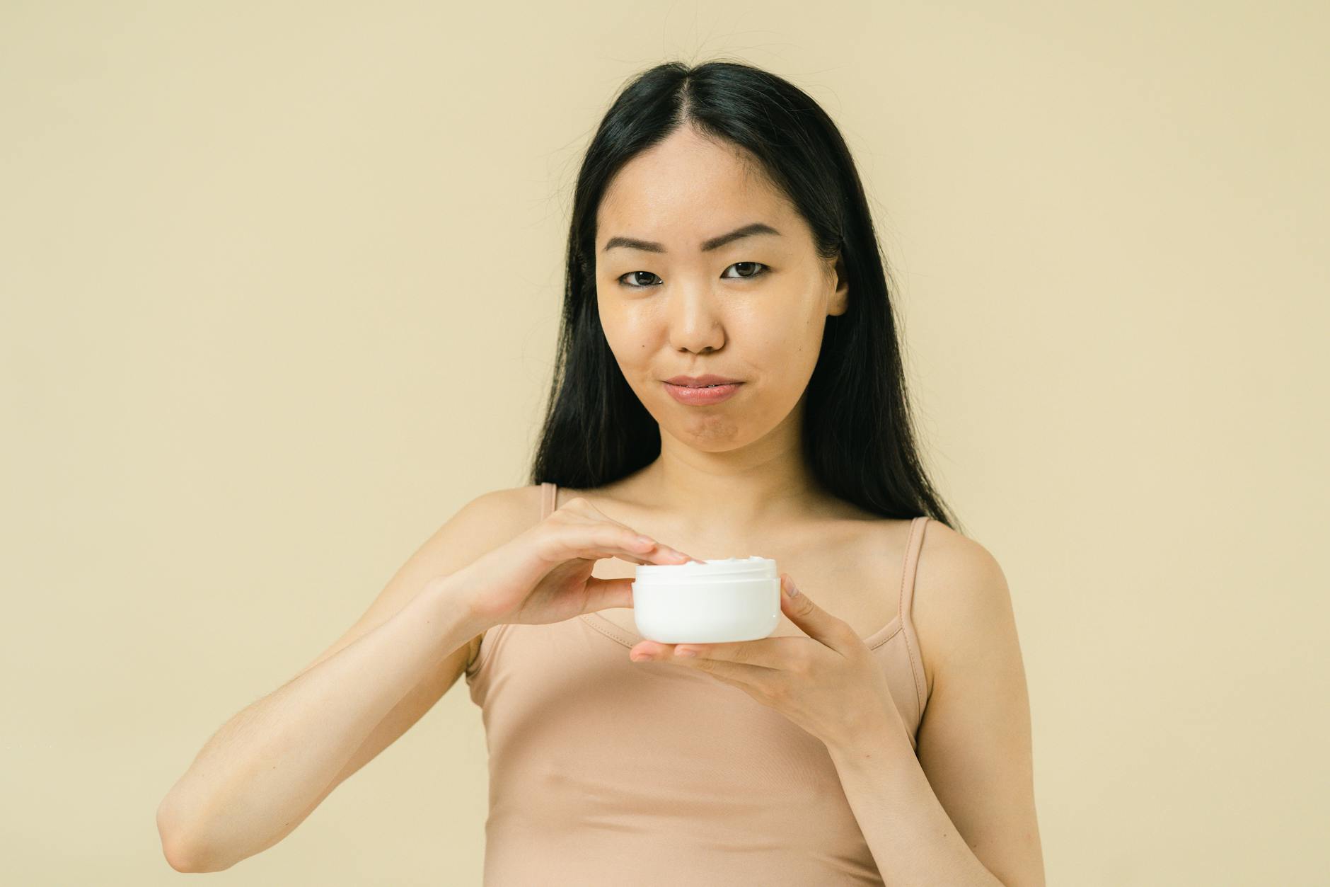 Femme appliquant une crème contour des yeux