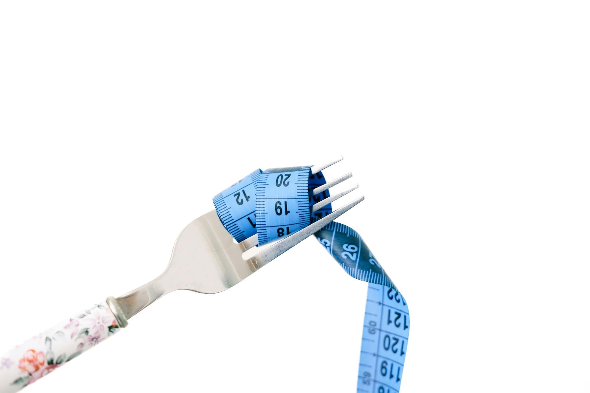 Flacon de complement minceur pose pres d'un metre de couturiere et de fruits frais