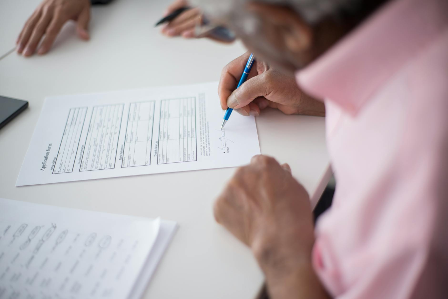 Stylo et contrat de mutuelle posés sur un bureau lumineux