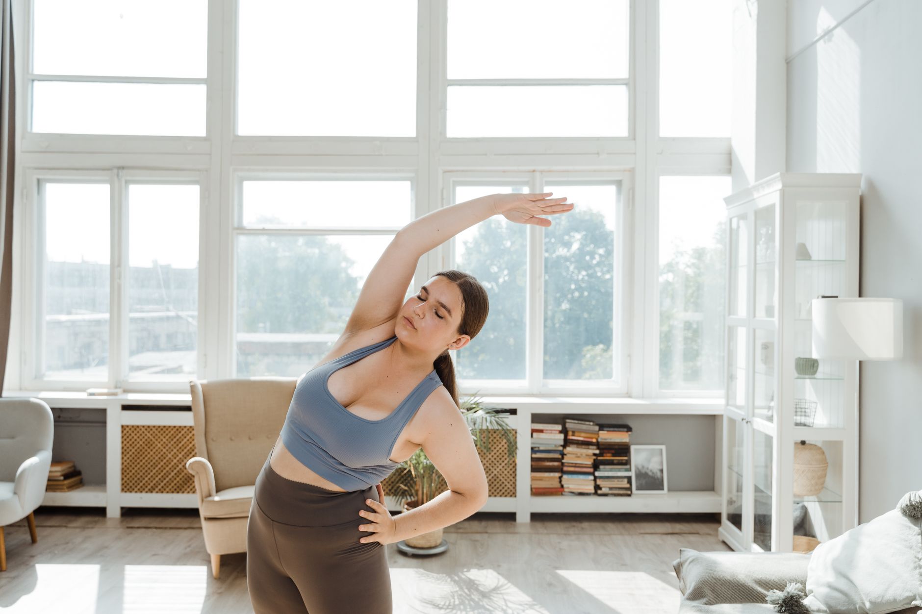 Femme s'étirant le matin près d'une fenêtre